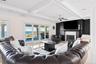 Living area with crown molding, coffered ceiling, a high end fireplace, beam ceiling, and ceiling fan