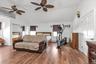 Bedroom featuring vaulted ceiling, a closet, a ceiling fan, wood finished floors, and a wall unit AC