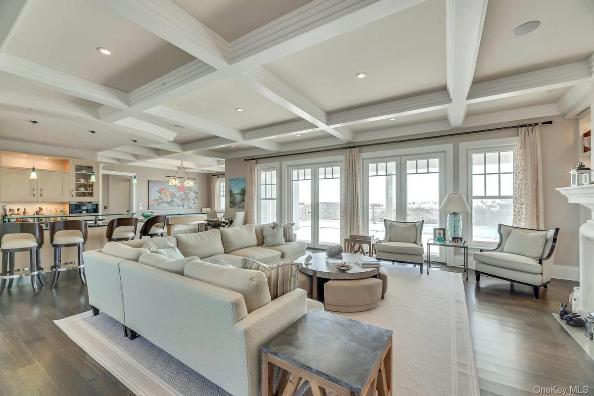 Living area featuring beam ceiling, wood-style floors, coffered ceiling, recessed lighting, and ornamental molding