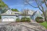 View of front of home featuring a garage, roof with shingles, decorative driveway, and french doors