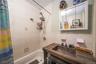Full bath with shower / tub combo with curtain, vanity, tile walls, and backsplash