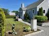View of home's exterior featuring a lawn, a shingled roof, and a chimney
