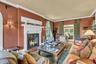 South facing den, 9.5 ft ceilings, featuring ornamental molding, a fireplace with flush hearth, arched windows, solid wood floors