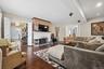 Elegant living room showcasing beautiful hardwood floors, a classic wood-burning fireplace, and a charming bay window that brings in abundant natural 