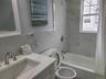 Bathroom featuring toilet, vanity, tile walls, and shower / tub combo with curtain