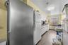 Kitchen with freestanding refrigerator, wood finished floors, white cabinetry, and light countertops