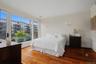 Alternate view of the primary suite showcasing private balcony access and views of the beautifully maintained community. (Bedding was virtually staged
