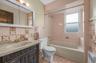 Bathroom featuring a vanity with an integrated sink, medicine cabinet, and a built-in bathtub with an overhead shower.