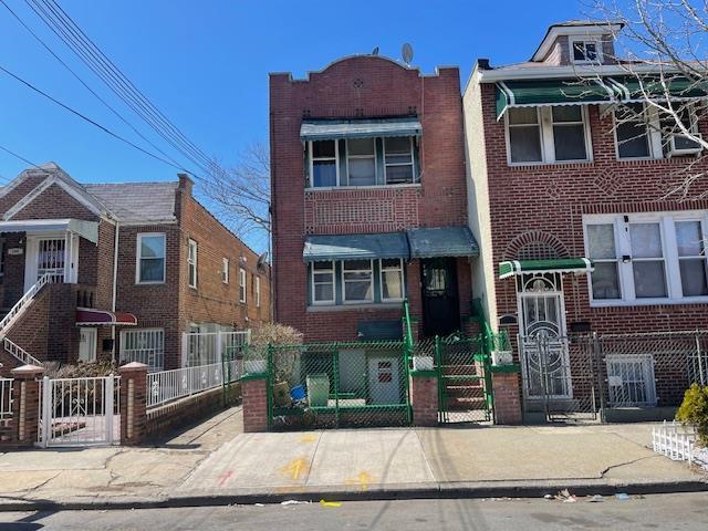 Townhome / multi-family property with brick siding, a fenced front yard, and a gate
