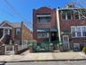 Townhome / multi-family property with brick siding, a fenced front yard, and a gate