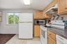 A spacious apartment kitchen featuring warm oak cabinetry, a generous cooking area, and clean, functional lines throughout.