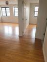 Corridor with a wealth of natural light and light hardwood / wood-style flooring