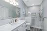Primary Suite Bathroom featuring a glass-enclosed shower with multiple showerheads
