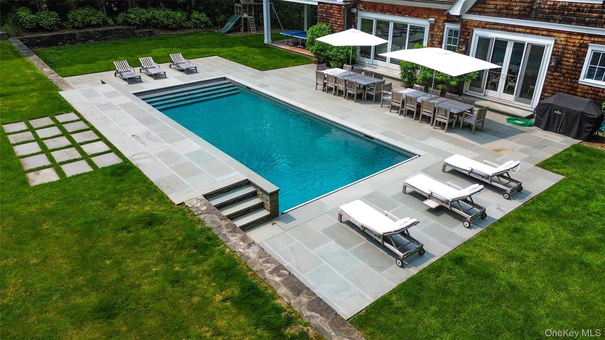 Expansive bluestone patio and resort style pool area