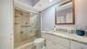 Primary bathroom with granite counters & glassed walk-in shower.