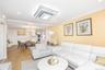 Living room featuring recessed lighting, ornamental molding, wood finished floors, and stacked washer / dryer