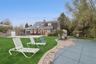 Back of house featuring a patio, a storage unit, a chimney, and outdoor dining area
