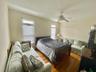 Bedroom featuring multiple windows, dark hardwood / wood-style floors, and ceiling fan