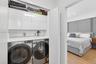 Laundry next to primary bedroom w/ folding counter and extra storage