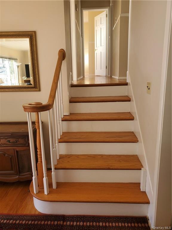 Stairs featuring wood finished floors