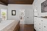 Bedroom featuring dark wood-type flooring, vaulted ceiling, wooden ceiling, and ensuite bathroom