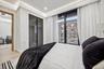 Bedroom with wood finished floors, a closet, and baseboards