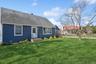 View of front of home featuring a front lawn, a shingled roof, and a chimney