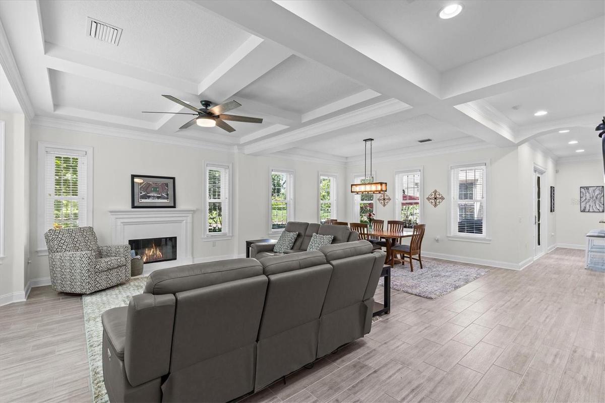 Soaring coffered ceiling and fireplace add elegance to the spacious living and dining rooms.