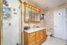 PRIMARY BATHROOM SUITE Bathroom with tile walls, tile patterned floors, vanity, a stall shower, and toilet