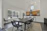 Dining space featuring a skylight, baseboards, high vaulted ceiling, and dark wood finished floors