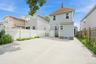 Spacious concrete paved yard featuring a white vinyl fence and a dedicated side entrance