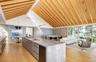 Kitchen featuring modern cabinets, a center island with sink, open floor plan, high vaulted ceiling, and light wood-style floors