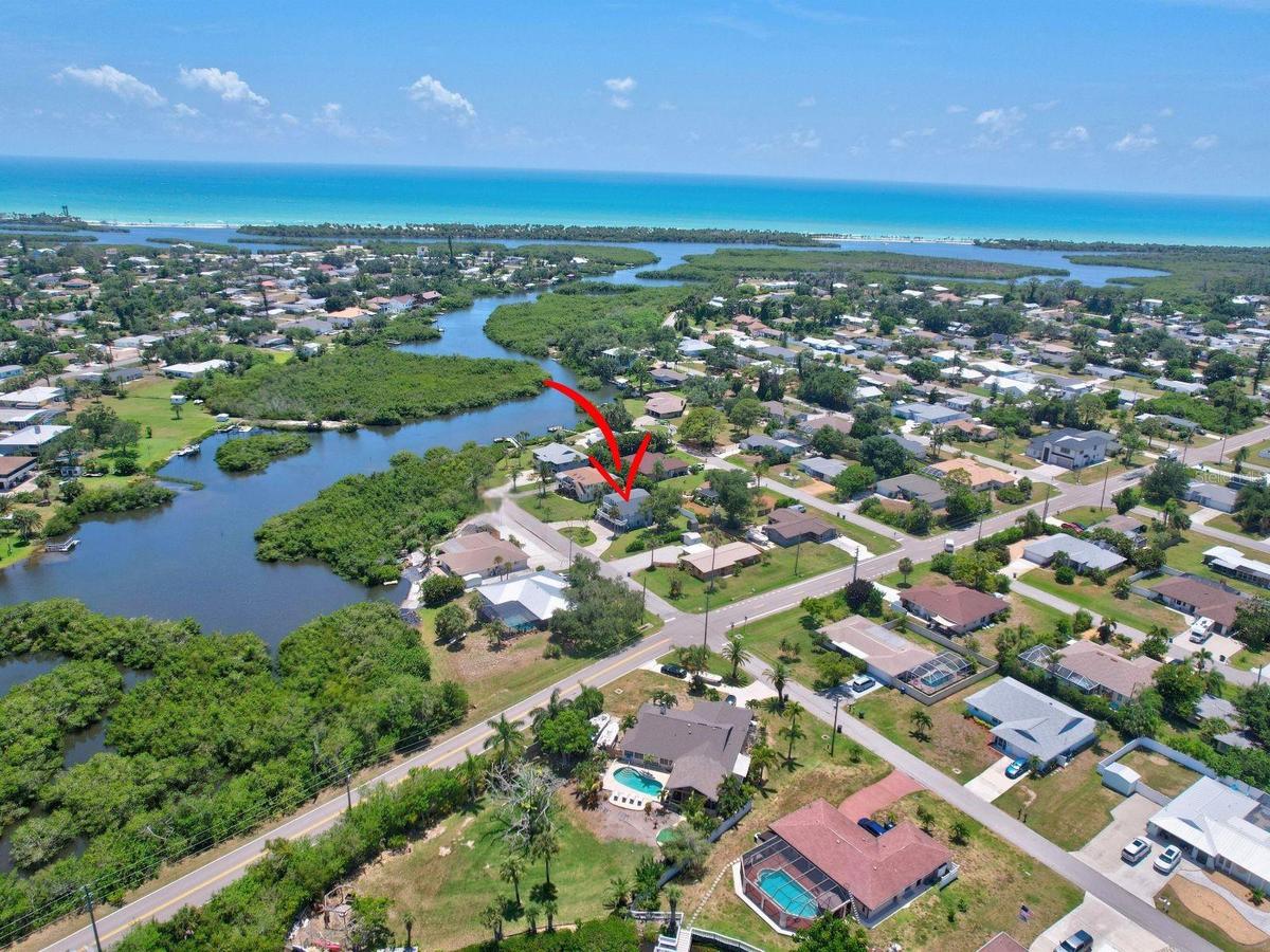 Elevated drone view showing the home's proximity to waterways and the Gulf Coast.