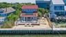 Waterfront property featuring a private wood dock and a sand-covered yard