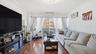 Living area featuring dark wood-style floors, ornamental molding, a wall mounted air conditioner, and a glass covered fireplace