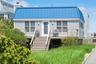 View of front of house with stairs, metal roof, and a deck