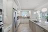 Bright kitchen with stone countertops and generous cabinetry.