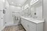 Large Primary Ensuite Bathroom with a double vanity and a large walk-in shower with frameless glass door and rainfall showerhead