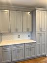 This gorgeous room features lots of sumptuous wooden cabinets (including that pantry), stainless steel appliances and quartz counter tops!