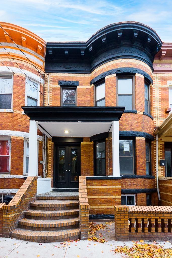 Entrance to property with brick siding, french doors, and covered porch