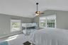 Carpeted bedroom with vaulted ceiling and ceiling fan