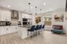 Modern kitchen featuring a large center island with seating, built-in appliances, solid surface countertops, and abundant cabinetry.