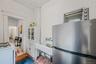 Kitchen with freestanding refrigerator, light wood finished floors, white cabinetry, a textured ceiling, and white range with gas cooktop