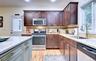 Legal accessory apartment: Kitchen featuring wood flooring, dark wood cabinetry