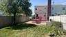 Spacious backyard featuring a mature shade tree, level lawn, and red composite deck with integrated stairs. Perfect for entertaining !!!