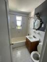 Bathroom with tile walls, vanity, and shower / washtub combination