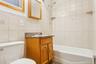 Bathroom featuring tile walls, vanity, shower combination, and decorative backsplash