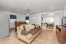 Living room with light tile patterned floors, a ceiling fan, and a baseboard radiator