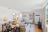 Living area featuring crown molding, light wood-style flooring, a chandelier, and a baseboard radiator