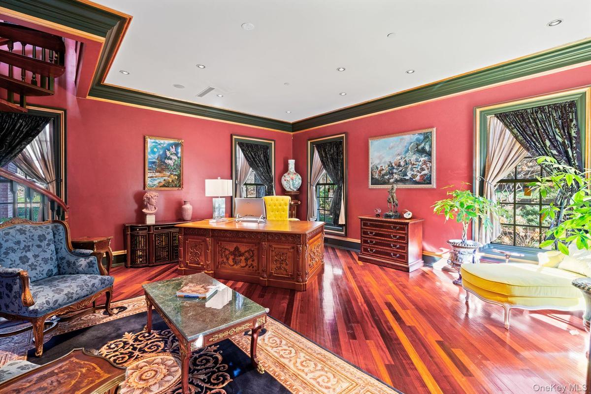 Room featuring rich red walls and dark green crown molding